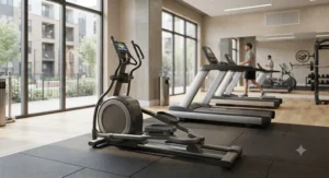 A well-organized apartment gym layout highlighting a compact low maintenance elliptical for apartment fitness center spaces alongside treadmills.
