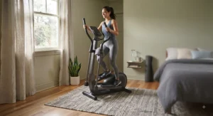 Fitness enthusiast using a compact elliptical trainer to stay active in a small bedroom.