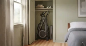 A foldable, compact elliptical machine being stored neatly in a small bedroom closet.