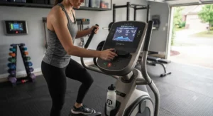 A person adjusting the settings on a heavy duty elliptical machine during a garage gym fitness session.