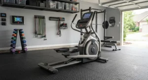 An organized home workout space in a garage featuring a heavy duty elliptical trainer as the centerpiece.