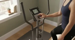 A fitness user adjusting the digital console and resistance levels on a budget elliptical inside a modern bedroom.