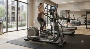 An apartment resident working out on a compact, low maintenance elliptical for apartment fitness center residents in a shared community gym.