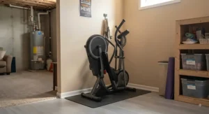 A foldable elliptical machine neatly tucked into a basement corner, showcasing effective space management for home gyms.